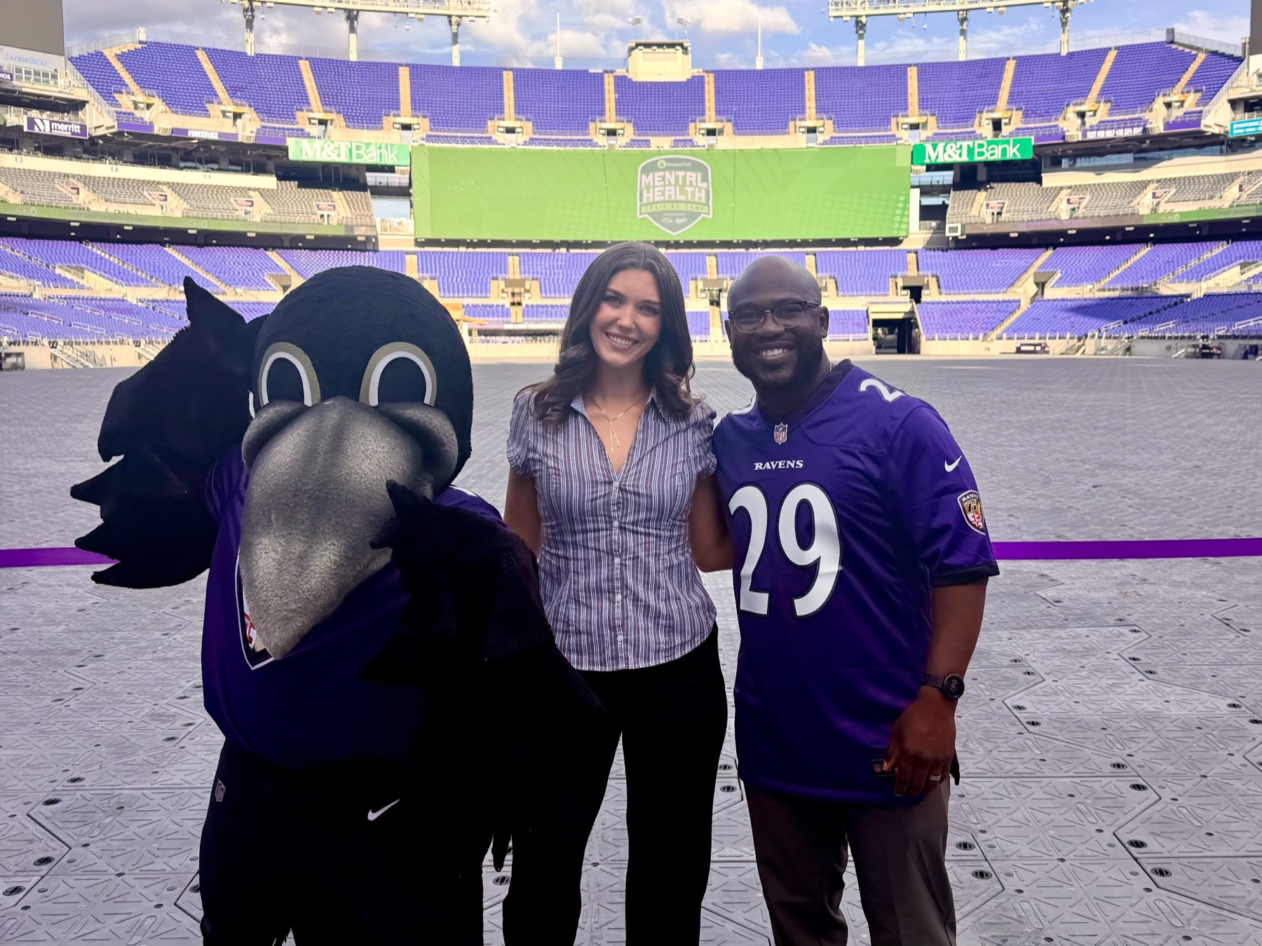 Amanda with the Baltimore Ravens mascot on the field at M&T Bank Stadium during the Mental Health Training Camp